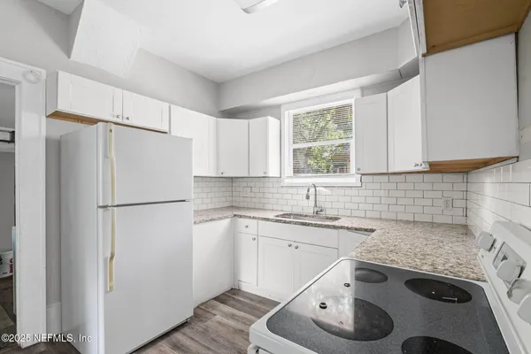a kitchen with a sink a refrigerator and a stove