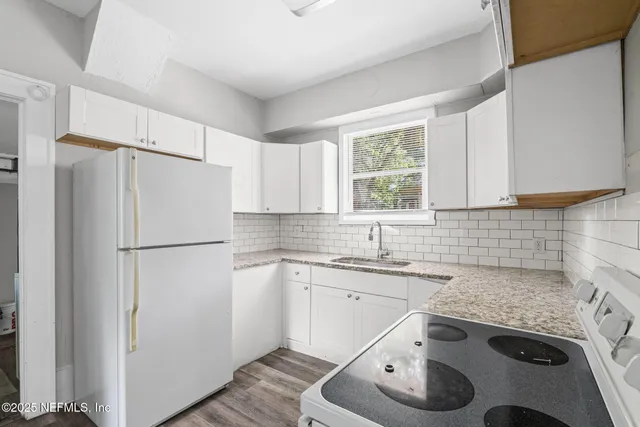 a kitchen with a sink a refrigerator and a stove