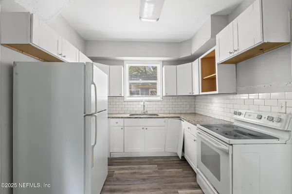 a kitchen with stainless steel appliances granite countertop a refrigerator sink and stove