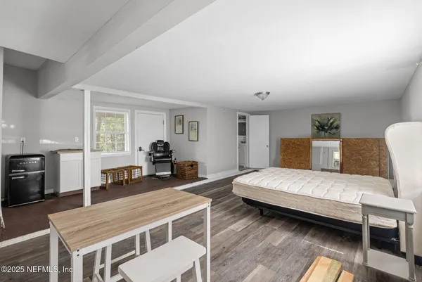 a bedroom with a bed and wooden floor