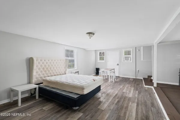 a bedroom with a bed and wooden floor