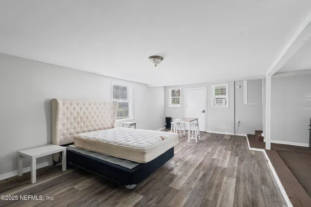 a bedroom with a bed and wooden floor