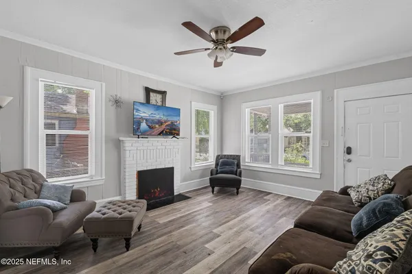 a living room with furniture a flat screen tv and a fireplace