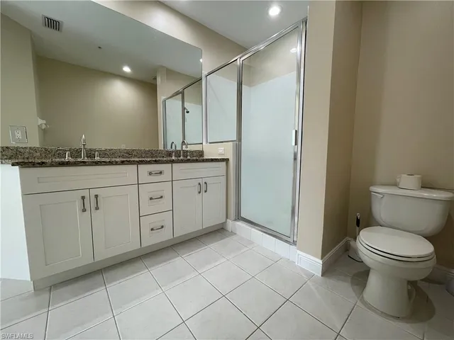 a bathroom with a granite countertop toilet a sink and a mirror