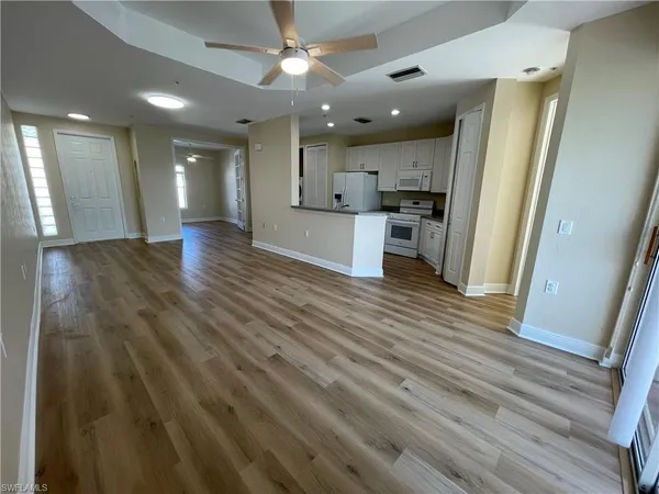 a view of kitchen and hall with wooden floor