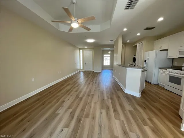 a view of a kitchen with wooden floor and a kitchen island