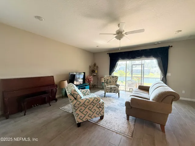 a living room with furniture a ceiling fan and a window