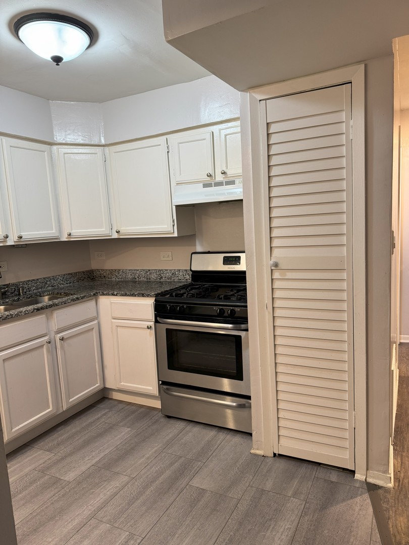 6027 103rd Street, Unit 1A Chicago Ridge, IL 60415 - Photo 10 of 22 a kitchen with granite countertop white cabinets and white appliances