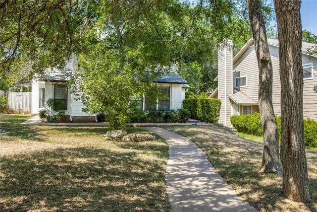 a view of a house with backyard and a tree
