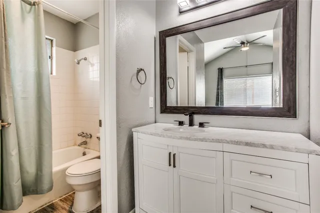 a bathroom with a granite countertop sink toilet a large mirror and shower