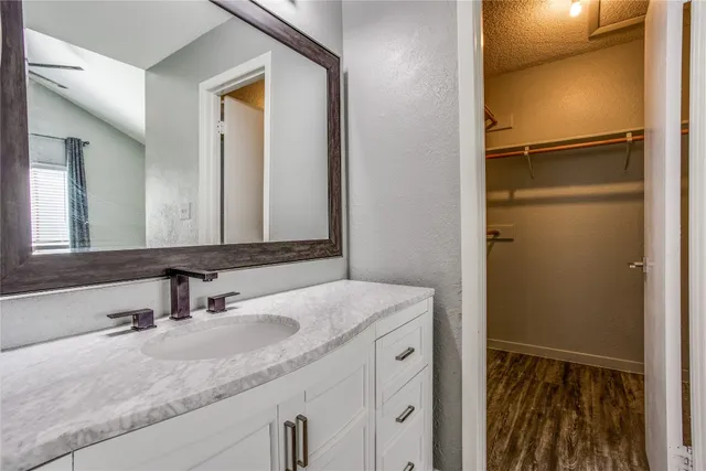 a bathroom with a granite countertop sink and a mirror
