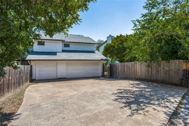 a front view of house with yard and trees in the background