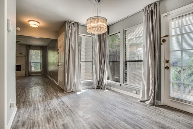 a view of a hallway with wooden floor and door