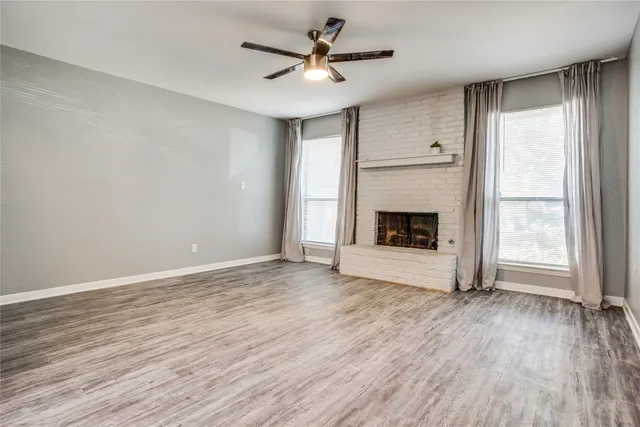 wooden floor fireplace and windows in an empty room