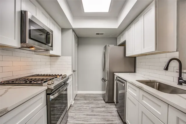 a kitchen with stainless steel appliances granite countertop a sink stove and refrigerator