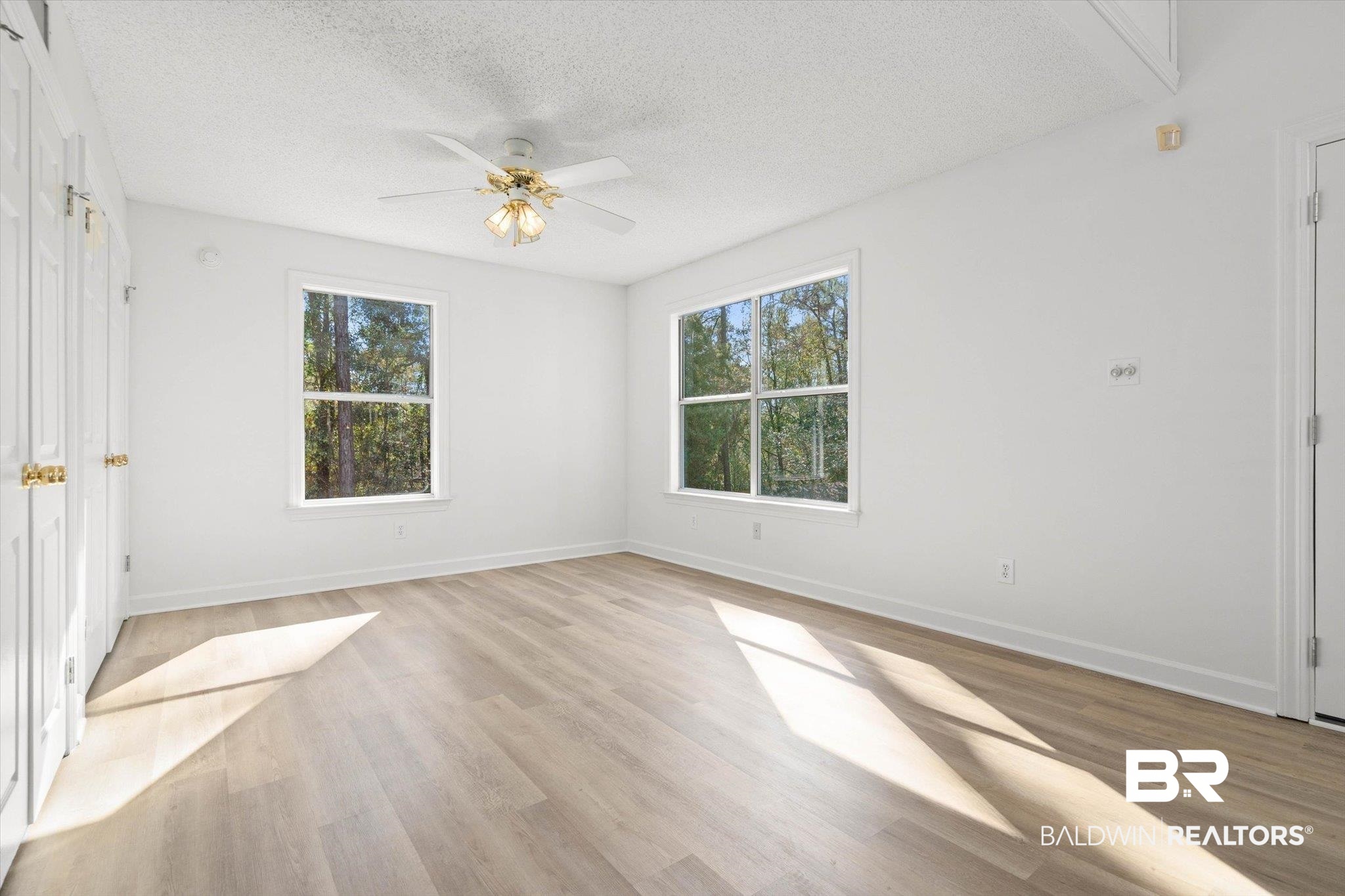 3847 Riviere Du Chien Road Mobile, AL 36693 - Photo 12 of 51 Unfurnished room with light wood-type flooring, ceiling fan, a textured ceiling, and plenty of natural light