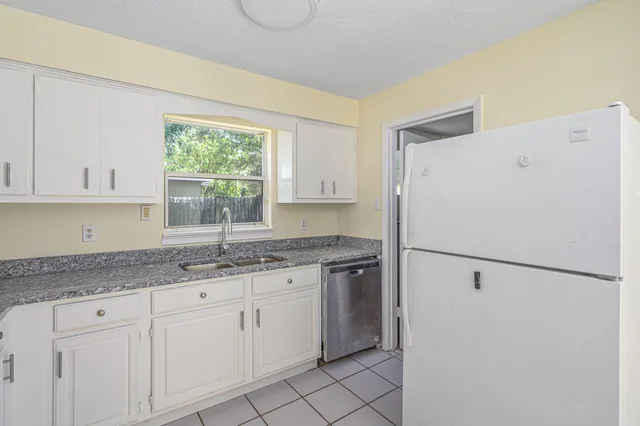 a kitchen with a sink a refrigerator and window