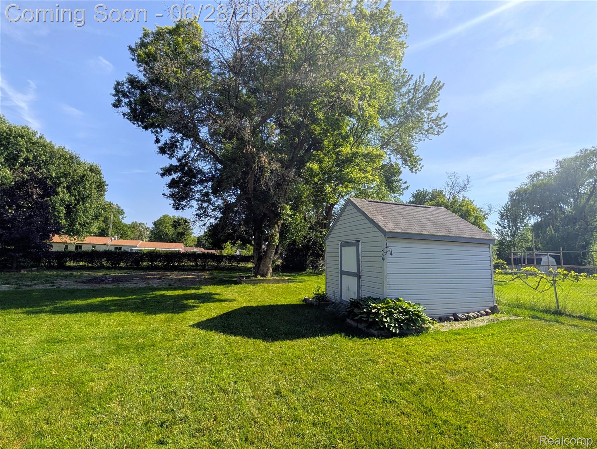 4456 East Coldwater Road Flint, MI 48506 - Photo 24 of 35 Expansive grassy yard featuring a detached storage shed with vinyl siding and an asphalt shingle roof