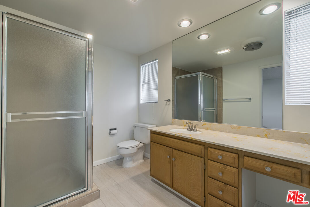 1342 Stradella Road Los Angeles, CA 90077 - Photo 15 of 24 a spacious bathroom with a shower sink mirror and toilet