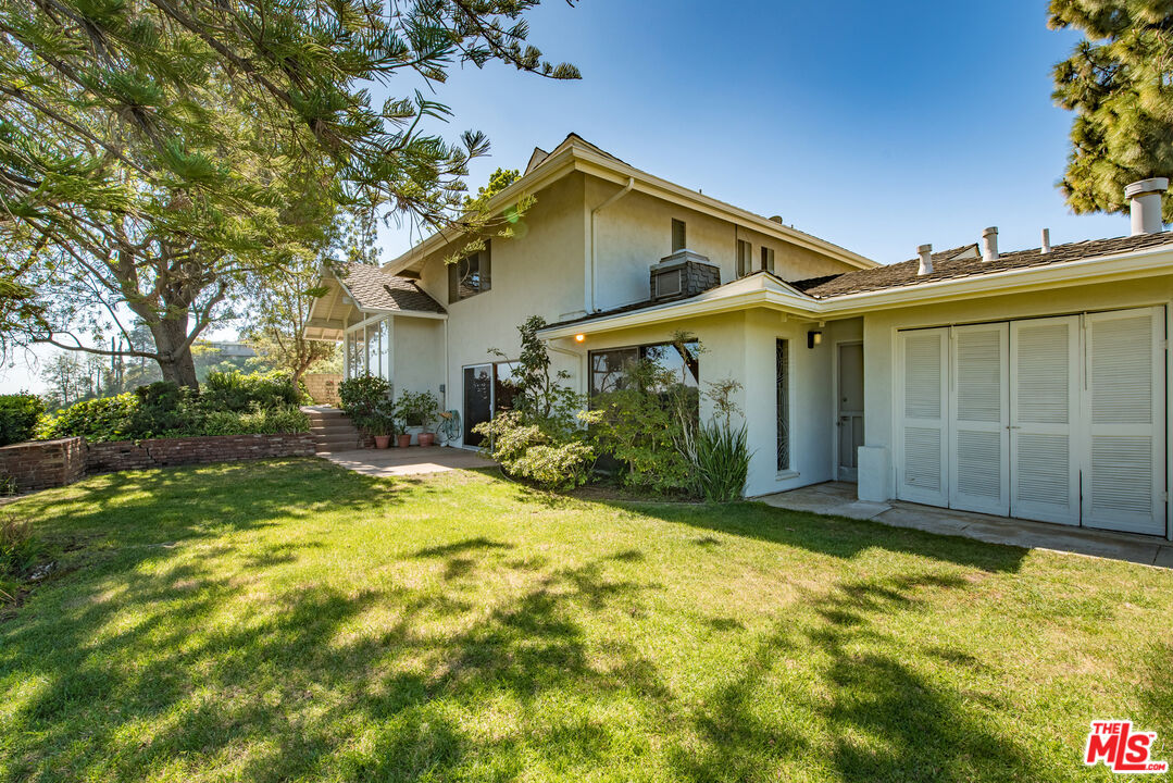 1342 Stradella Road Los Angeles, CA 90077 - Photo 17 of 24 a view of a house with a yard