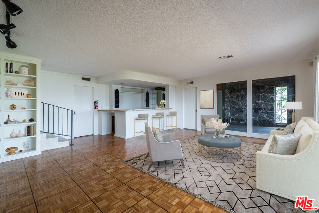 1342 Stradella Road Los Angeles, CA 90077 - Photo 8 of 24 a living room with furniture a rug and white walls