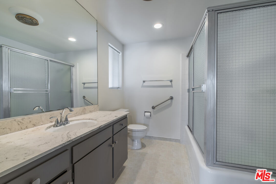 1342 Stradella Road Los Angeles, CA 90077 - Photo 10 of 24 a bathroom with a granite countertop sink a toilet and shower
