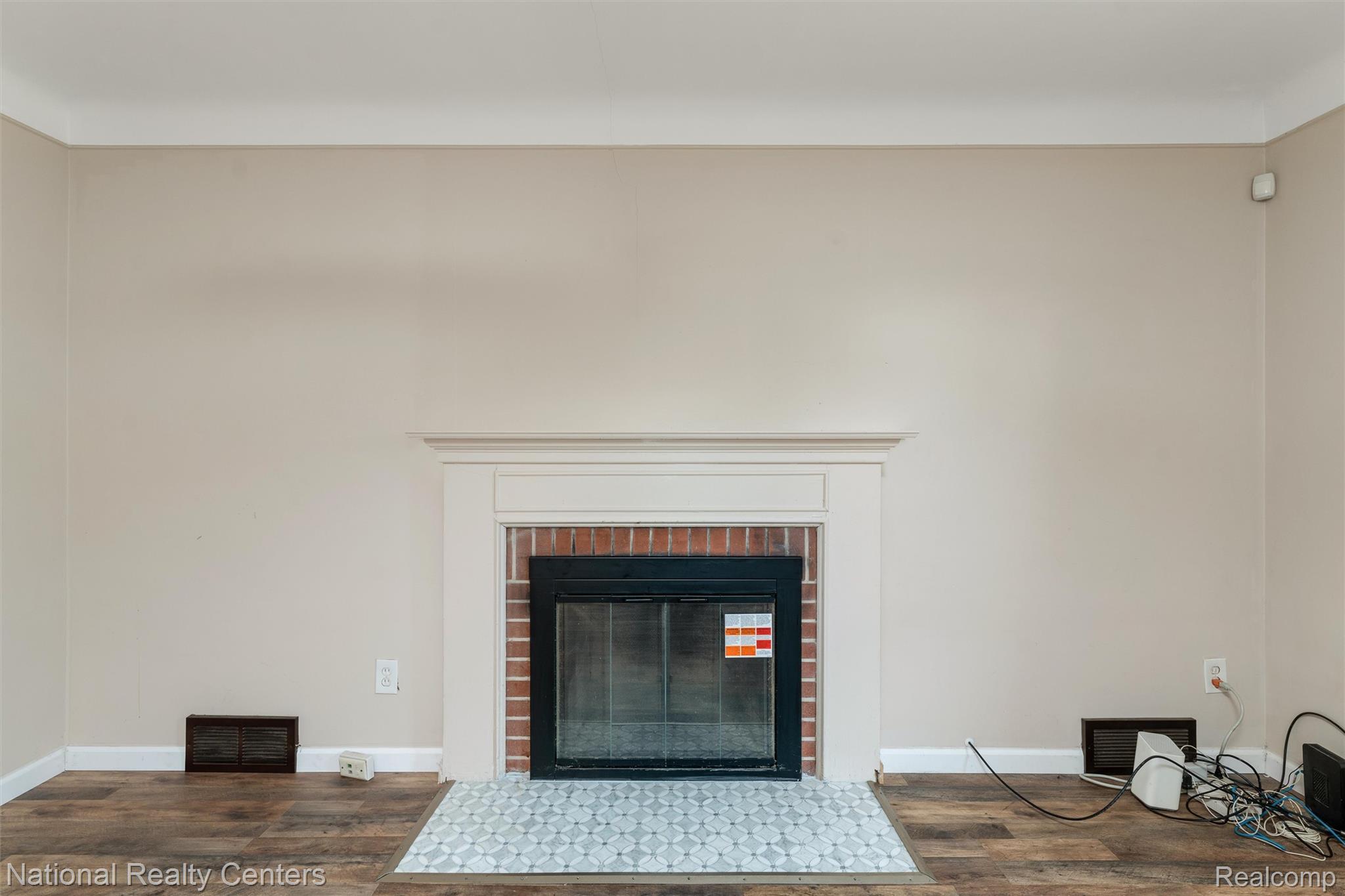 5525 Cadieux Road Detroit, MI 48224 - Photo 4 of 19 Detailed view of wood finished floors and a fireplace