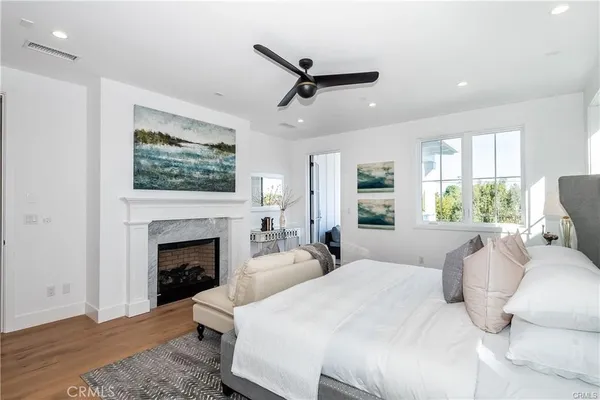 a large white bedroom with a bed and a fireplace