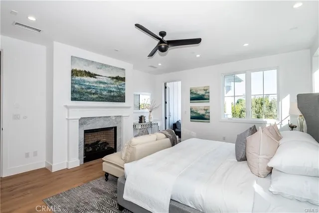 a large white bedroom with a bed and a fireplace