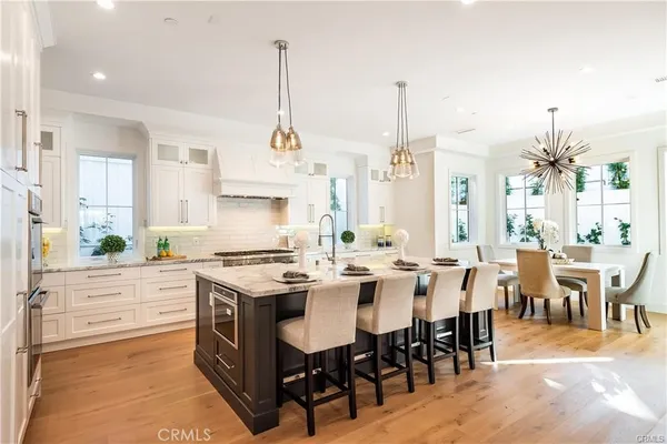 a kitchen with appliances a sink a stove and chairs