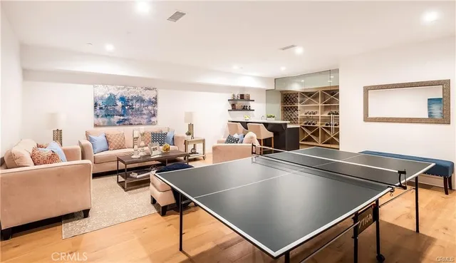 a living room with stainless steel appliances furniture and kitchen view