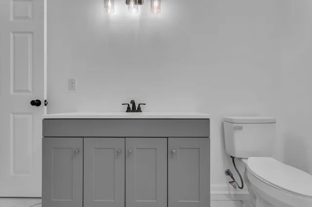 a bathroom with a toilet a sink and mirror