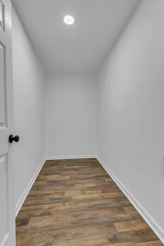 a view of an empty room with wooden floor