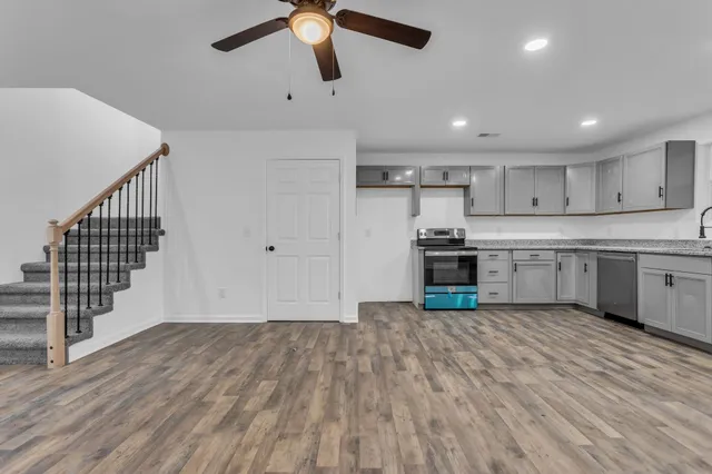 a kitchen with granite countertop a stove a sink and a refrigerator