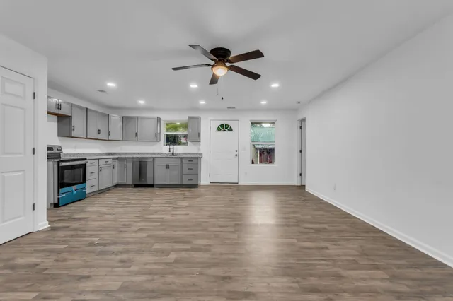 a large kitchen with stainless steel appliances granite countertop a stove and a refrigerator