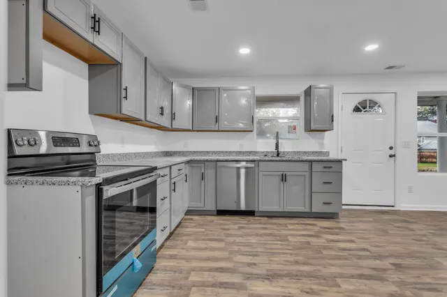 a kitchen with stainless steel appliances granite countertop a sink and stove top oven