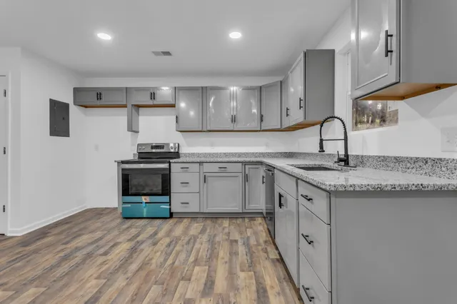 a kitchen with stainless steel appliances granite countertop a sink stove and cabinets