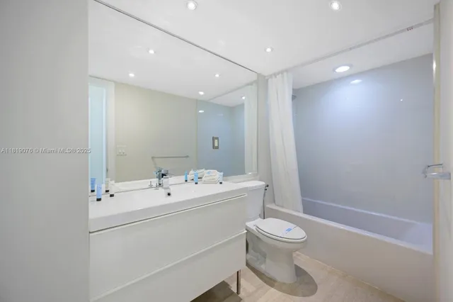 a bathroom with a toilet a sink a mirror and a shower