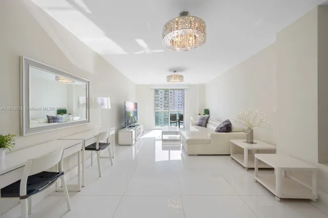 a living room with furniture a chandelier and a dining table