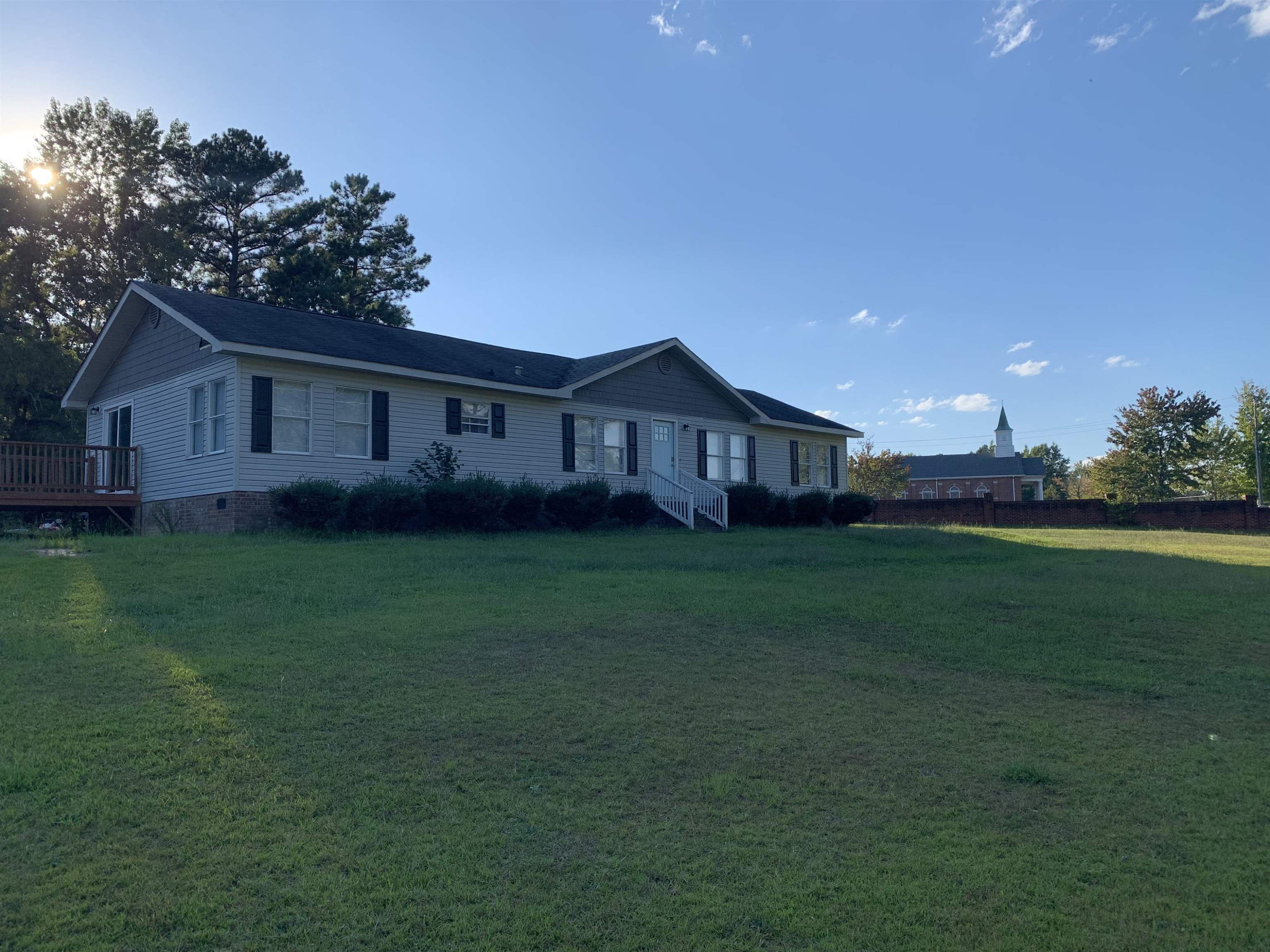 a view of a house with a big yard potted plants and large tree