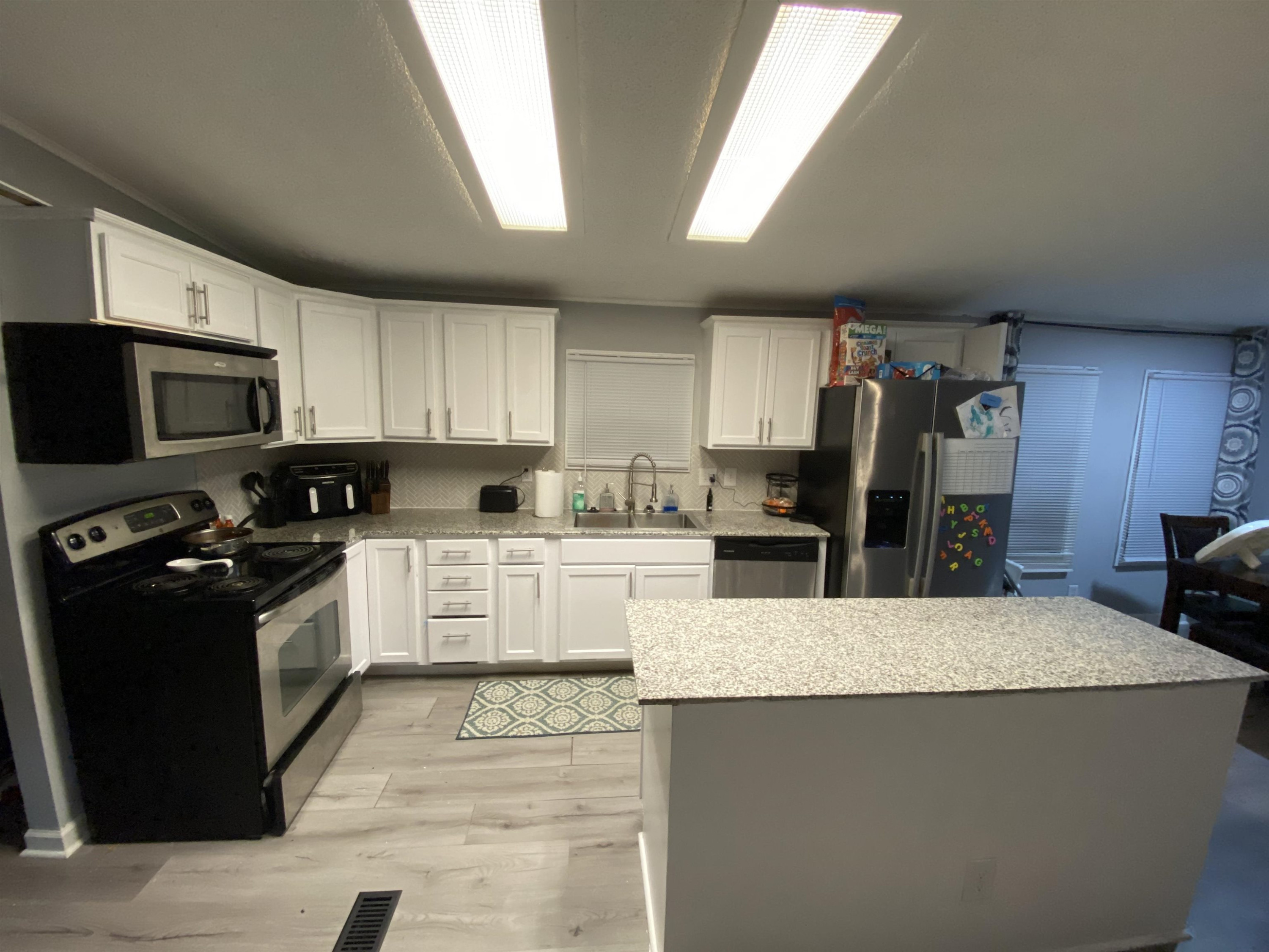 6036 Rock Quarry Road Raleigh, NC 27610 - Photo 8 of 17 a kitchen with stainless steel appliances granite countertop a stove top oven a sink dishwasher and a refrigerator