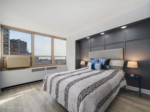 a bedroom with a bed and a large window with outer view