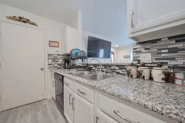 wooden floor in an empty room with a kitchen