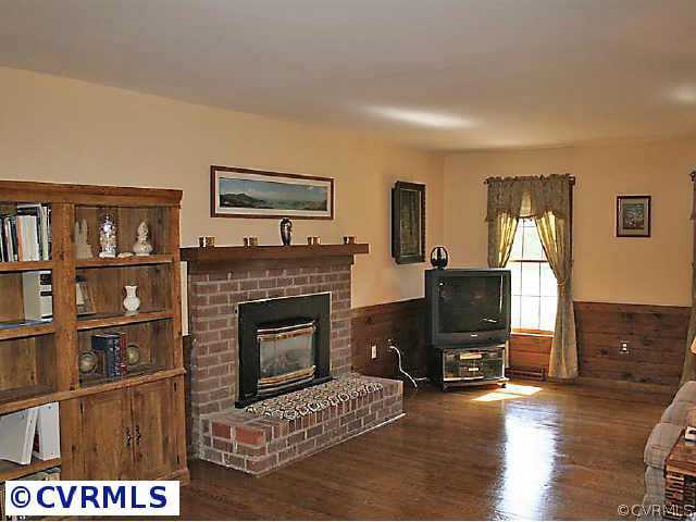 7158 Barkbridge Road Chesterfield, VA 23832 - Photo 7 of 10 a living room with furniture a fireplace and a flat screen tv