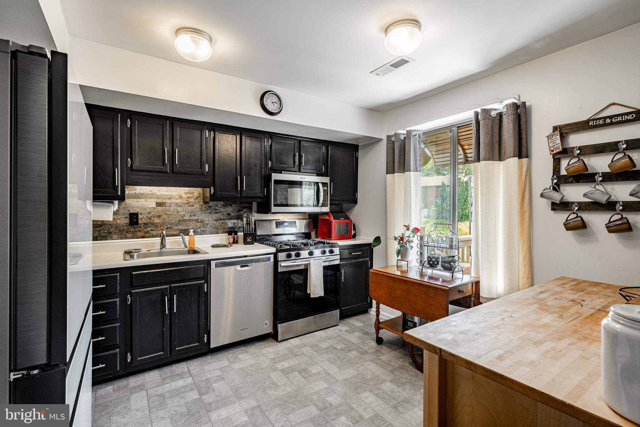 32-4 Wister Way Reading, PA 19606 - Photo 12 of 47 a kitchen with kitchen island stainless steel appliances a sink stove refrigerator and cabinets