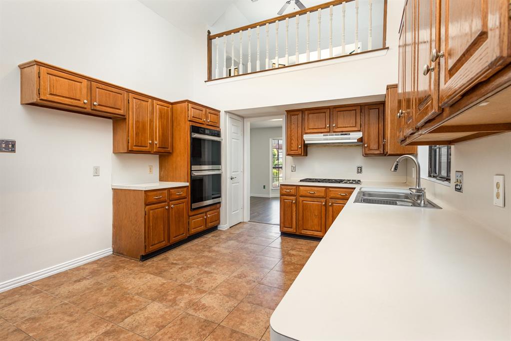6029 Buffridge Trail Dallas, TX 75252 - Photo 13 of 30 a kitchen with stainless steel appliances granite countertop a stove a sink and a refrigerator