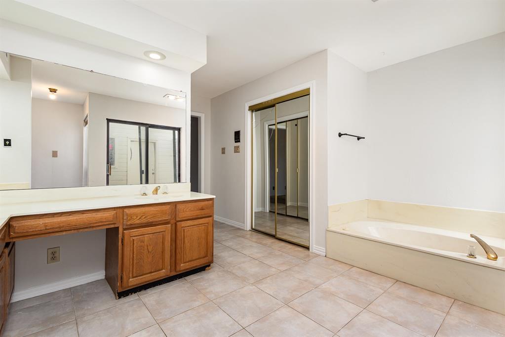 6029 Buffridge Trail Dallas, TX 75252 - Photo 18 of 30 a spacious bathroom with a tub sink and mirror