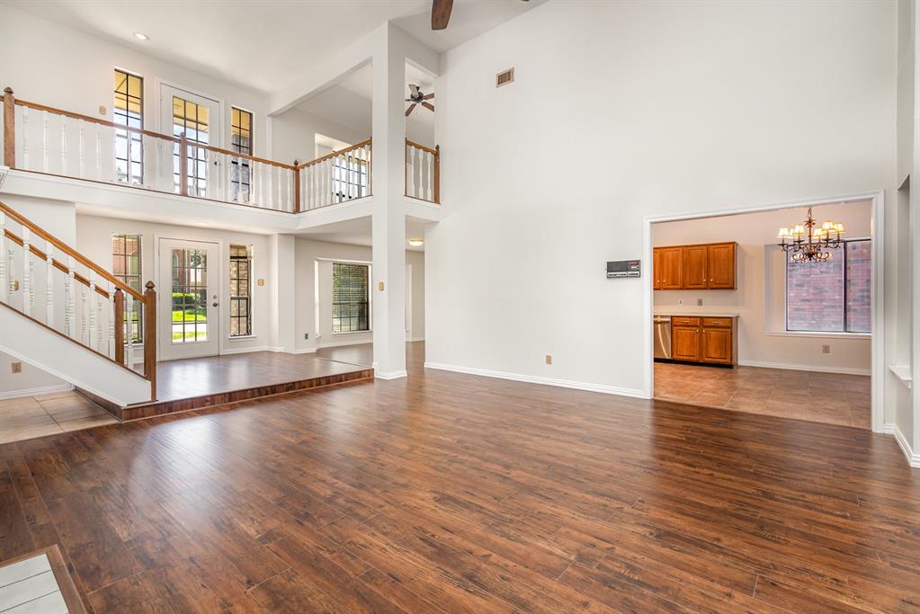 6029 Buffridge Trail Dallas, TX 75252 - Photo 5 of 30 a view of an empty room with wooden floor and a window