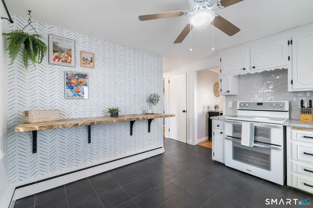 a kitchen with granite countertop white cabinets and stainless steel appliances
