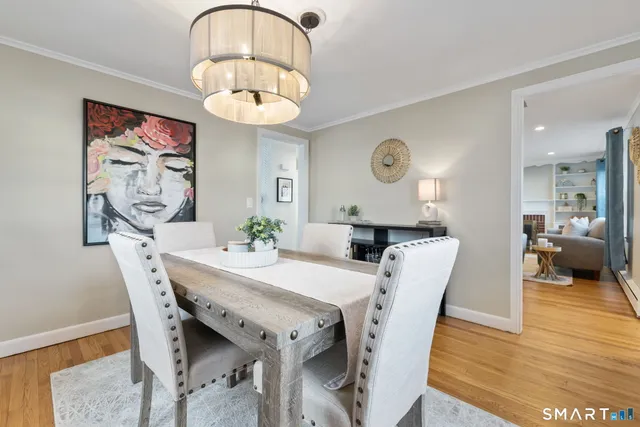 a view of a dining room with furniture a chandelier and wooden floor